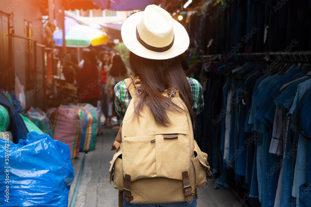 Asian woman travel with backpack walking in market in Thailand