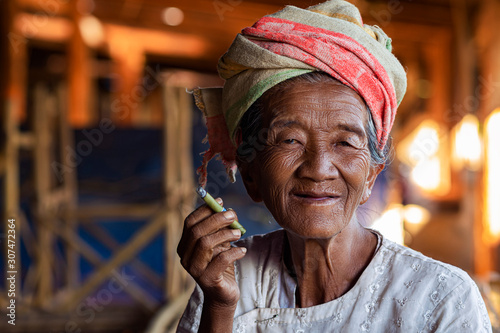 Fotomurale Portrait of Happy Old Burmese Lady Smoking a Cigar at Indein Village Near Inle L