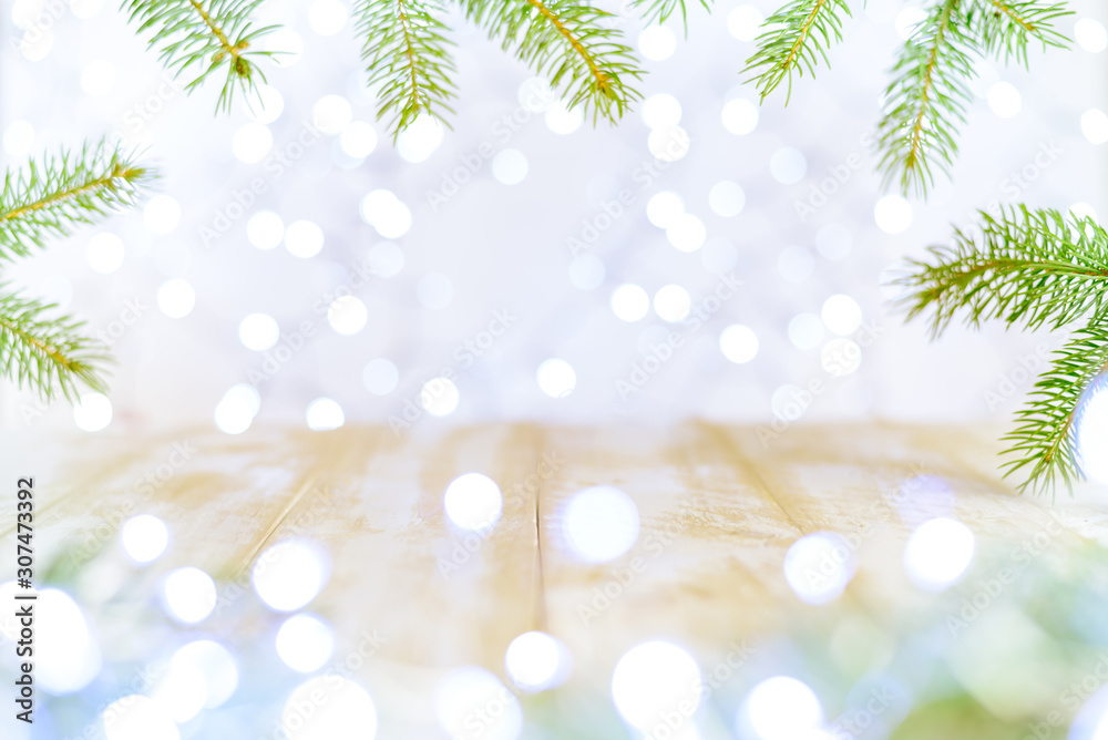 Christmas bokeh background with fir branches and an empty light wooden table. Copy space, soft focus Christmas bokeh background with fir branches and an empty light wooden table. Copy space, soft focus