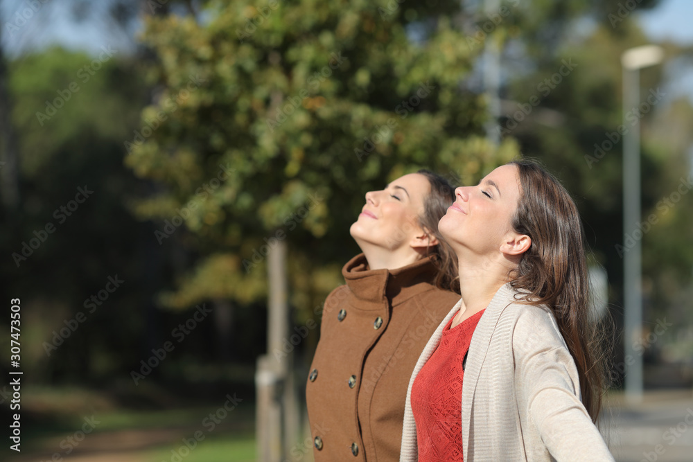 Two relaxed women breathing fresh air in winter in a park Two relaxed women breathing fresh air in winter in a park