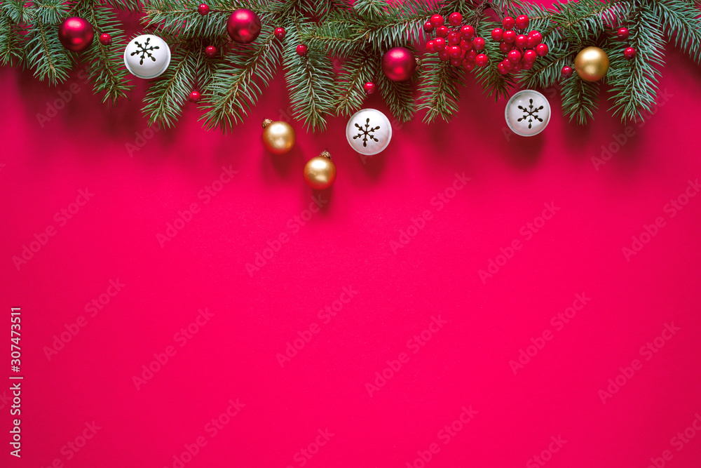 Christmas winter background, Christmas card. Fir branches and holiday decorations on a red background, top view with space for text.	