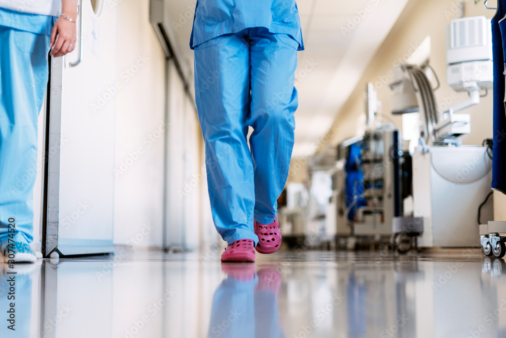 Unrecognizable nurse walking through hospital hallway Unrecognizable nurse walking through hospital hallway