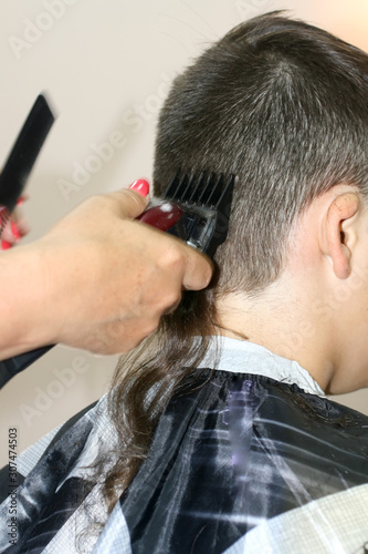 Haircut of a boy at the hairdresser. Trimer.