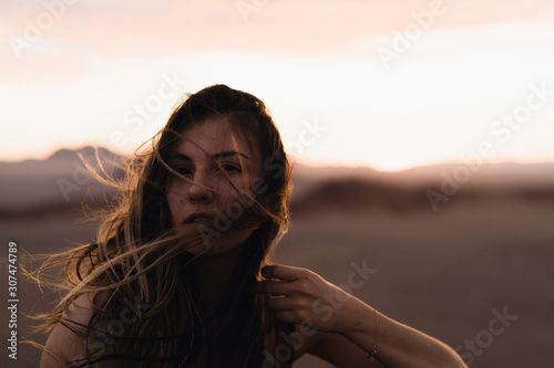 A portrait of a girl in the sunset with a blown hair photo