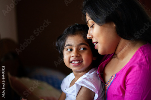 Little girl sharing cheerful moment with her mother photo