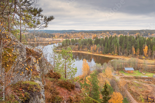 Fototapeta Naklejka Na Ścianę i Meble -  View from the top of the Snake Mountain on Lake Ladoga and a stone island with a forest, Skhera, near the town of Lahdenpohja in Karelia, Russia, in the autumn day