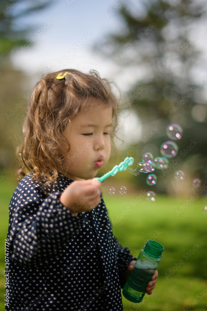 Little girl blowing bubbles outside Little girl blowing bubbles outside