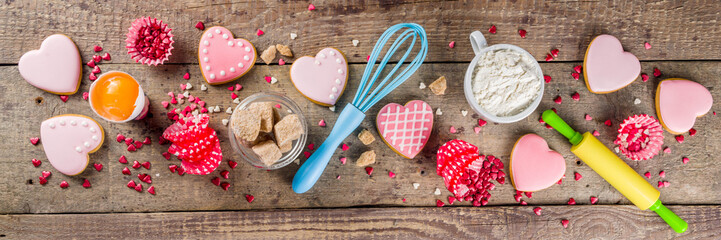 Valentine day cooking baking background. Utensils and ingredient for sweet Valentine cakes and heart shaped cookies, wooden background copy space