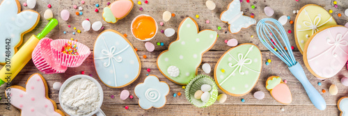 Easter cooking baking background with pastel colored easter cookies, sugar sprinkles and ingredients for bake cake and cookies Fototapet