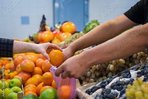 Woman buying fresh vegetables at street market.