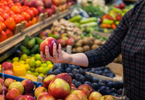 Fotografie Caucasian girl buying fresh vegetables food products at the market