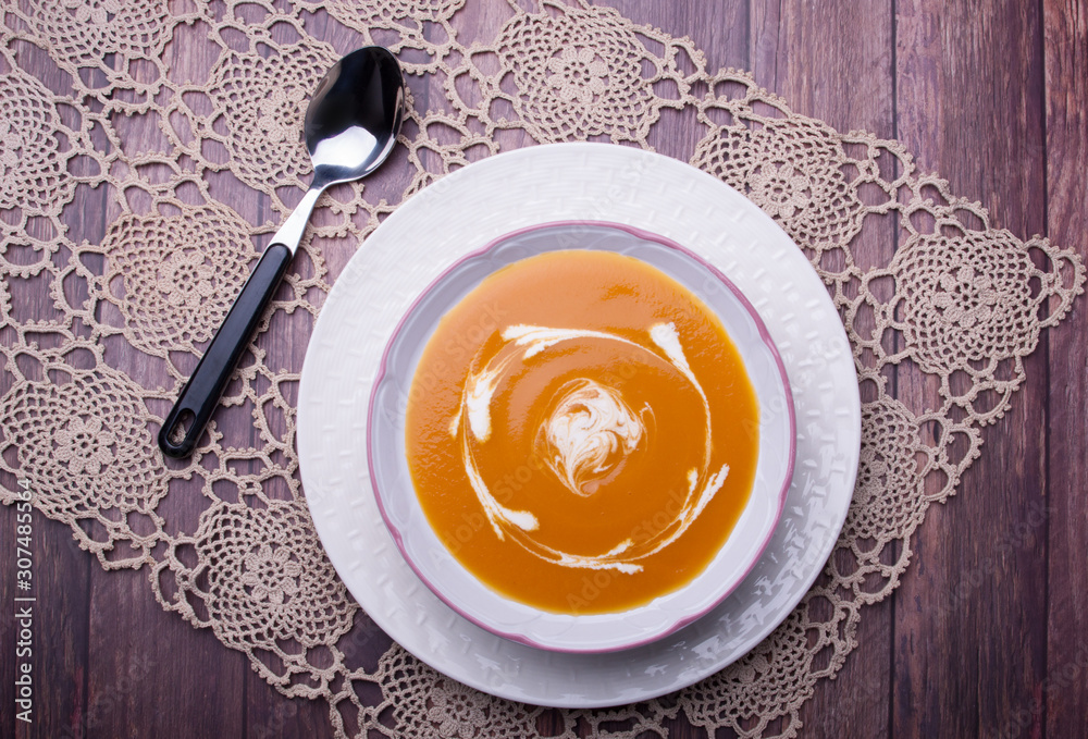 Closeup on a carrot cream-soup with heavy cream Closeup on a carrot cream-soup with heavy cream