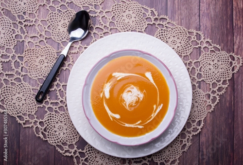 Closeup on a carrot cream-soup with heavy cream photo