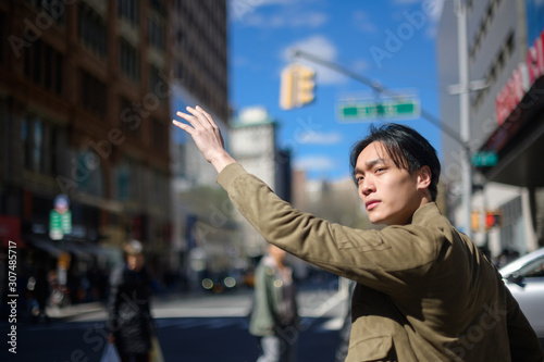 Young man catching cab on street
