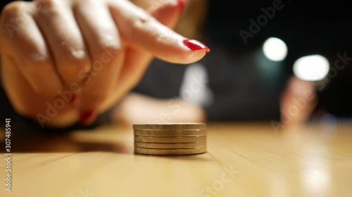 coins lie on the table and the girl’s finger points to them