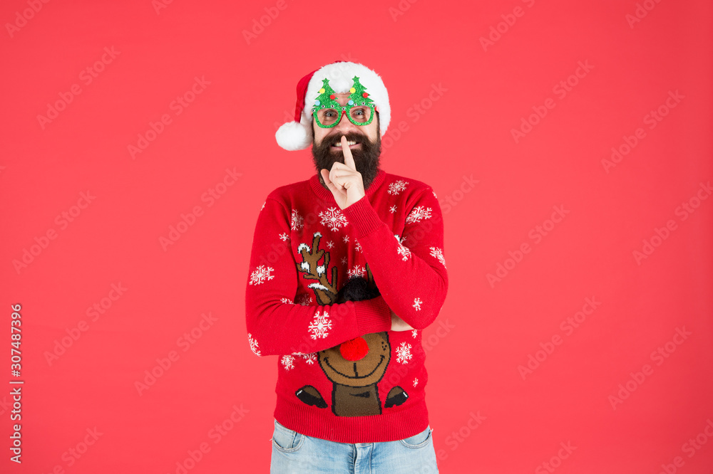 Keep secret. Happy new year celebration. Join holiday celebration. Winter party outfit. Sweater with deer. Hipster bearded man wear winter clothes red background. Christmas celebration ideas Keep secret. Happy new year celebration. Join holiday celebration. Winter party outfit. Sweater with deer. Hipster bearded man wear winter clothes red background. Christmas celebration ideas