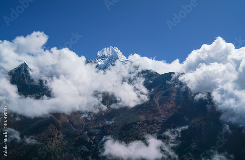  Thamserku 6608m mountain summit covered with clouds landscape photo in the eastern Nepal Himalayas.
