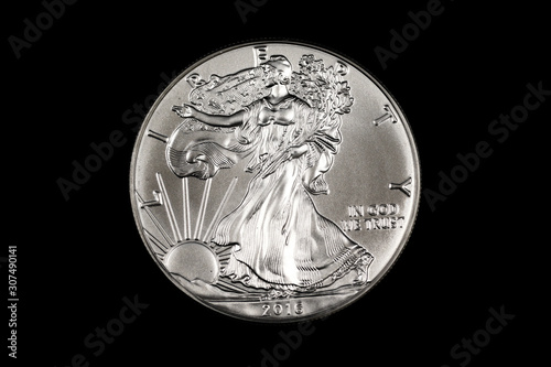An American one ounce silver Eagle coin, shot close up in macro on a solid black background