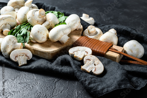 fresh mushrooms champignon on a wooden cutting Board. Black background. Top view