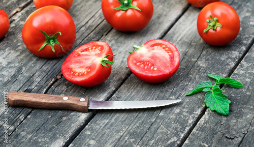 .knife and tomatoes on a wooden background