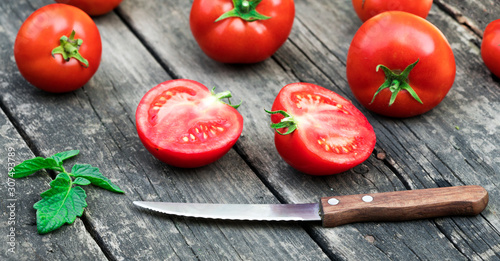 .knife and tomatoes on a wooden background
