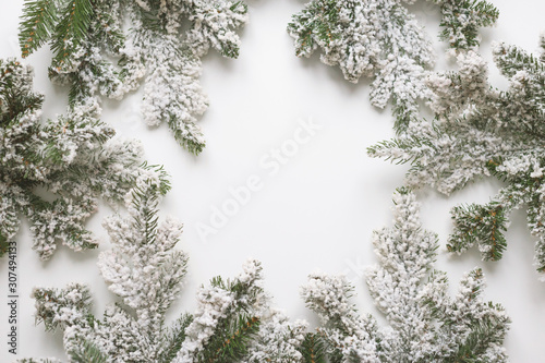 Christmas still life. Spruce branches form a frame with white copespace in the middle photo