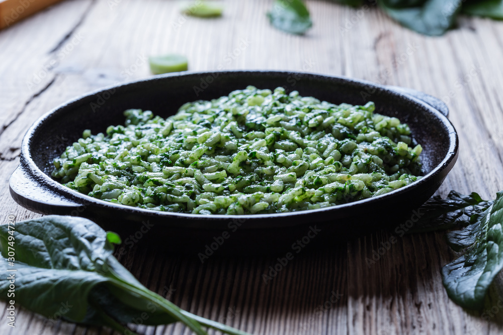Vegan dish, spinach risotto in cast iron skillet Vegan dish, spinach risotto in cast iron skillet