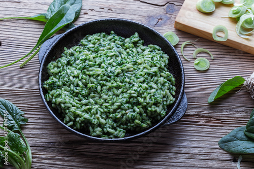 Vegan dish, spinach risotto in cast iron skillet photo