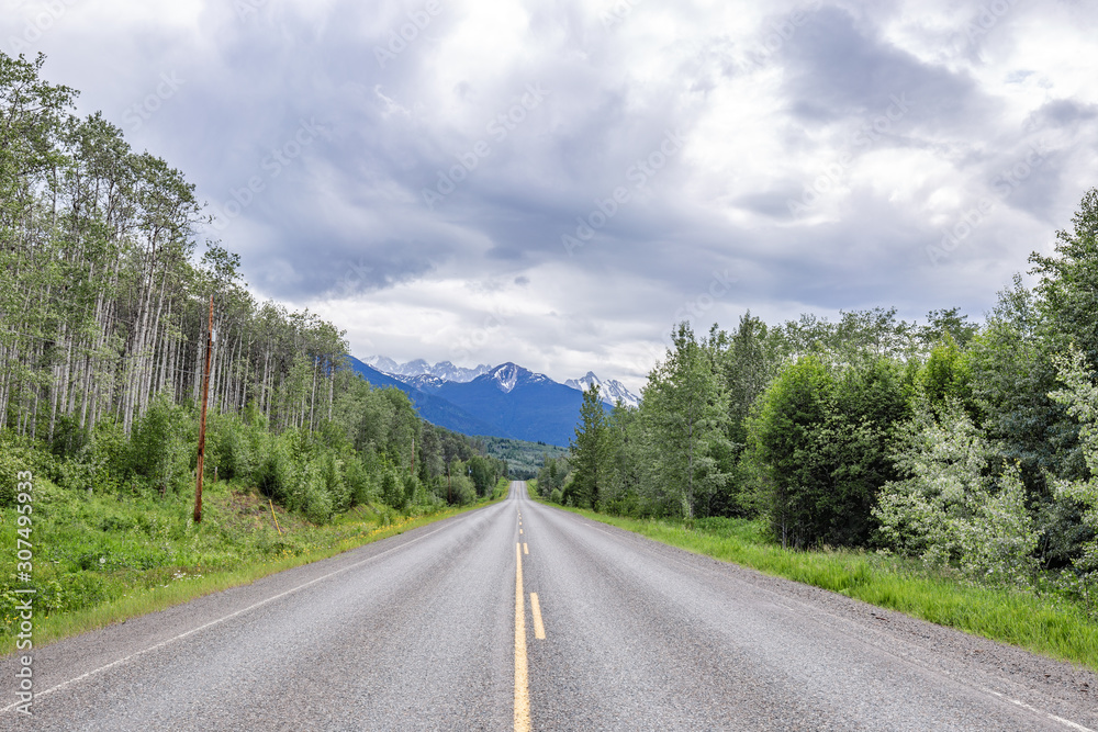 Fototapeta premium Scenic road leading to snow covered mountains