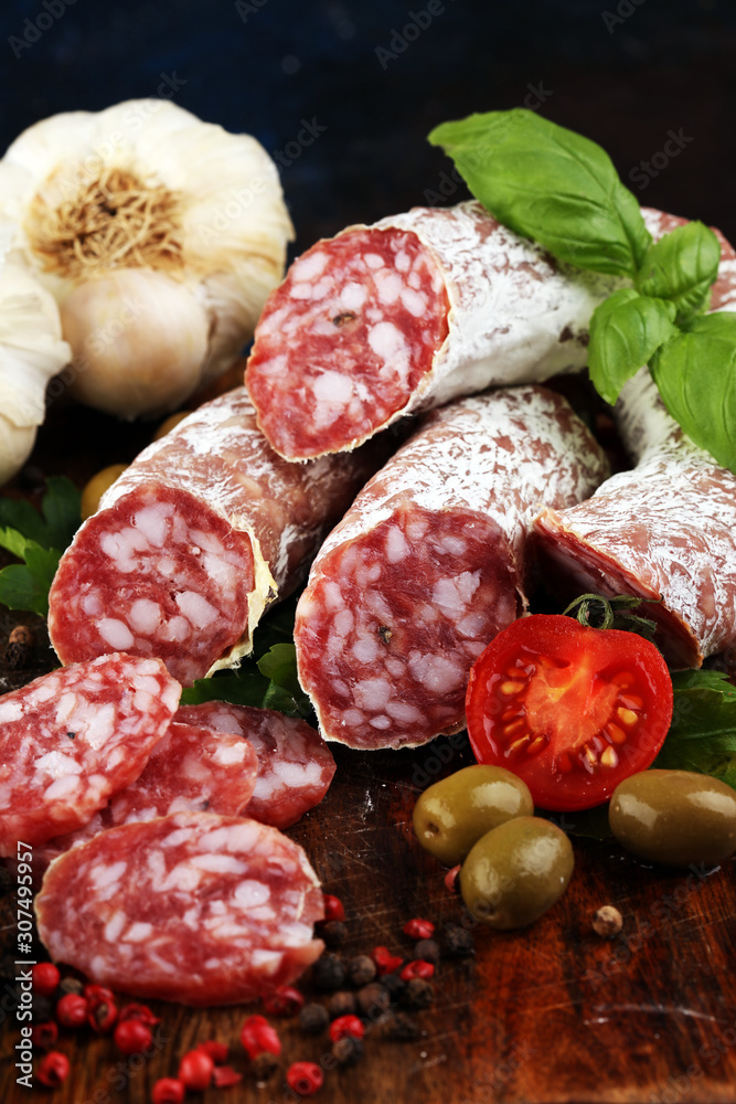 thinly sliced salami on a wooden texture on the background. thinly sliced salami on a wooden texture on the background.