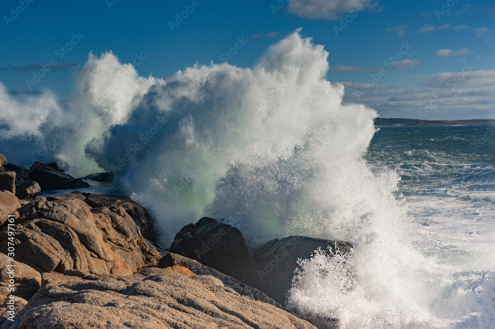Obraz premium Waves breaking against rocks