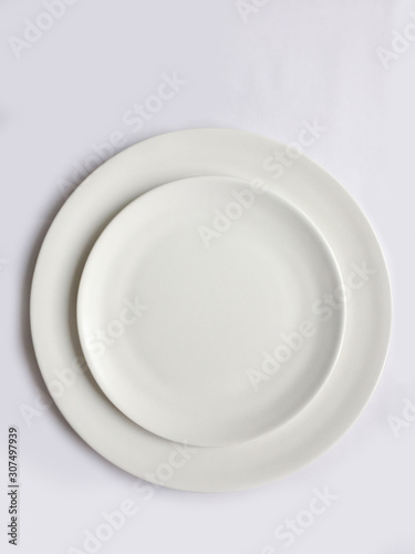 Elegant cutlery view from above on a isolated white background. Top view. Porcelain two ivory saucer. Trendy plate pastel shades. Flat lay view.
