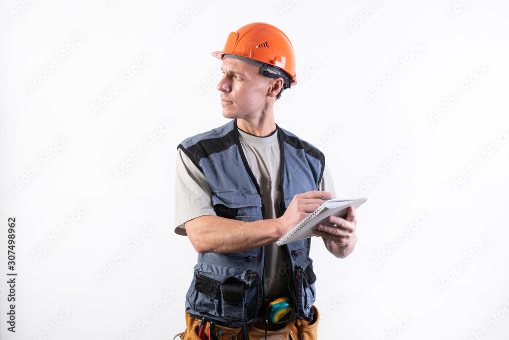Builder with a notepad. In a helmet and a robe. Writes data.