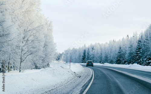 Car on Winter road with snow in Finland. Auto and Cold landscape of Lapland. Automobile on Europe forest. Finnish City highway ride. Roadway and route snowy street trip. Driving © Roman Babakin