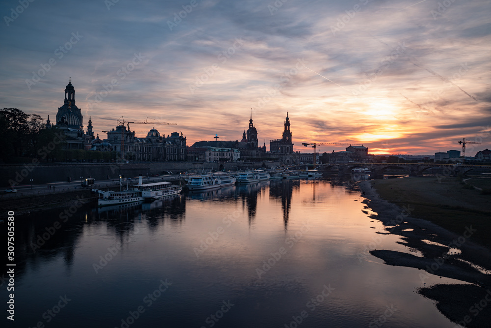 Boats moored on Elbe river against sky in city during sunset, Saxony, Germany Boats moored on Elbe river against sky in city during sunset, Saxony, Germany