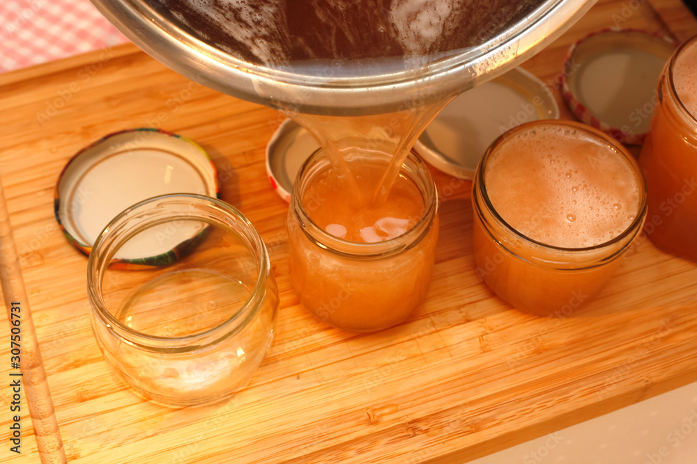 Pouring quince jelly into jars Pouring quince jelly into jars
