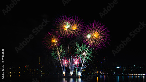 Beautiful fireworks against the background as over city scape view of night city in Thailand. © Anek