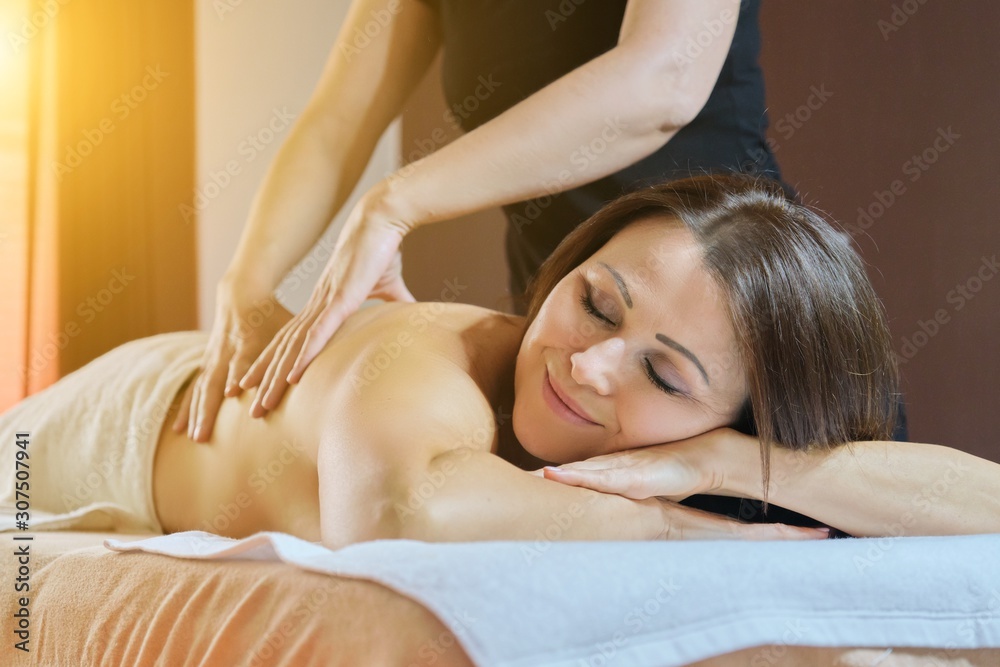 Fototapeta premium Professional back massage procedure, adult woman receiving treatment