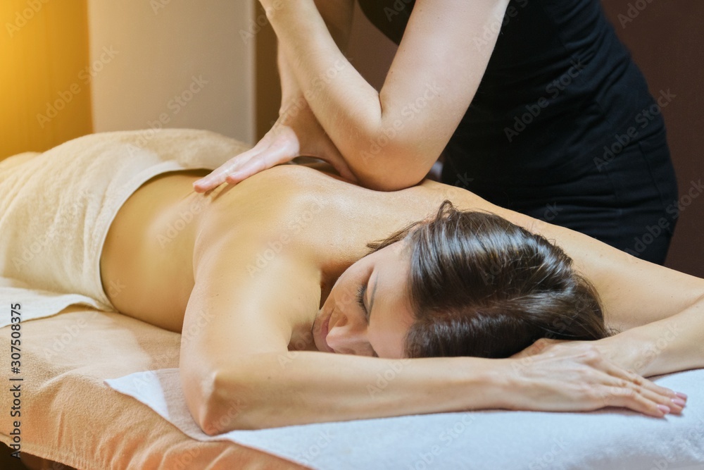 Obraz premium Mature woman lying on massage table and receiving medical back massage