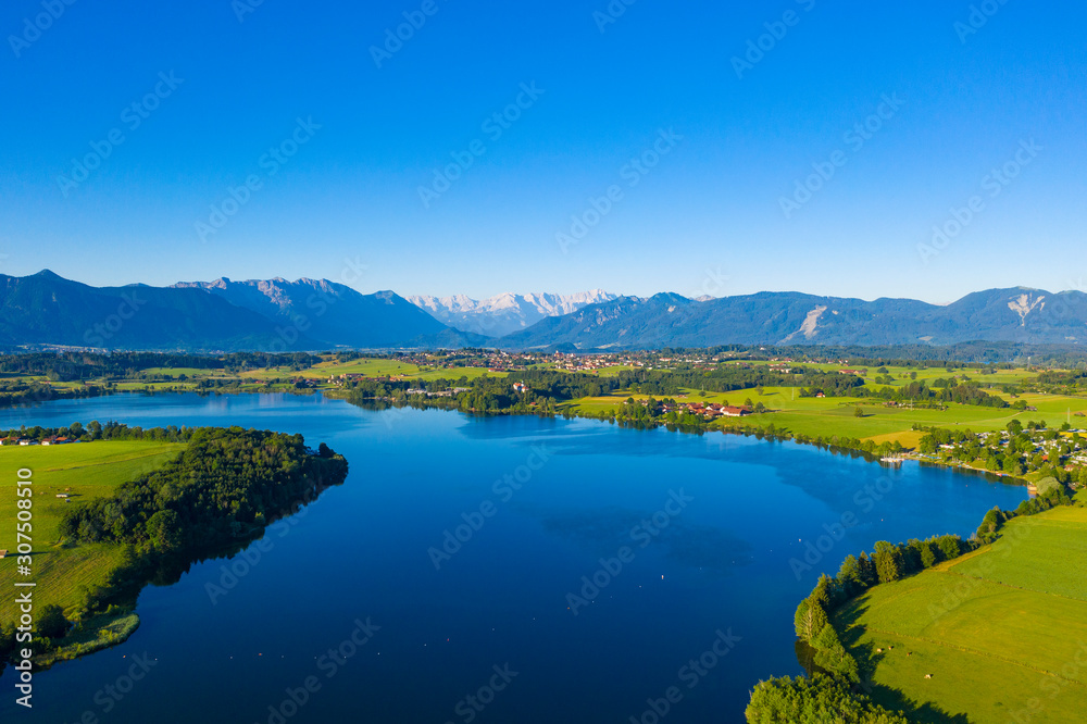 Scenic view of Riegsee lake and green landscape against clear blue sky, Germany Scenic view of Riegsee lake and green landscape against clear blue sky, Germany