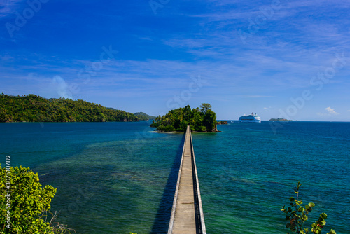 High angle view of empty footbridge leading towards island against blue sky, during sunny day Samana peninsula, Dominican Republic photo