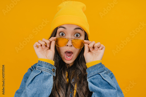 Canvastavla Close up of surprised asian woman in yellow hat and sunglasses looking excitemen