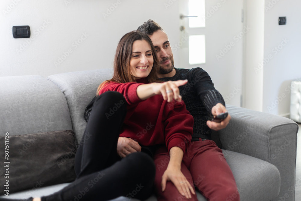 Obraz premium Couple watching a movie together on a couch