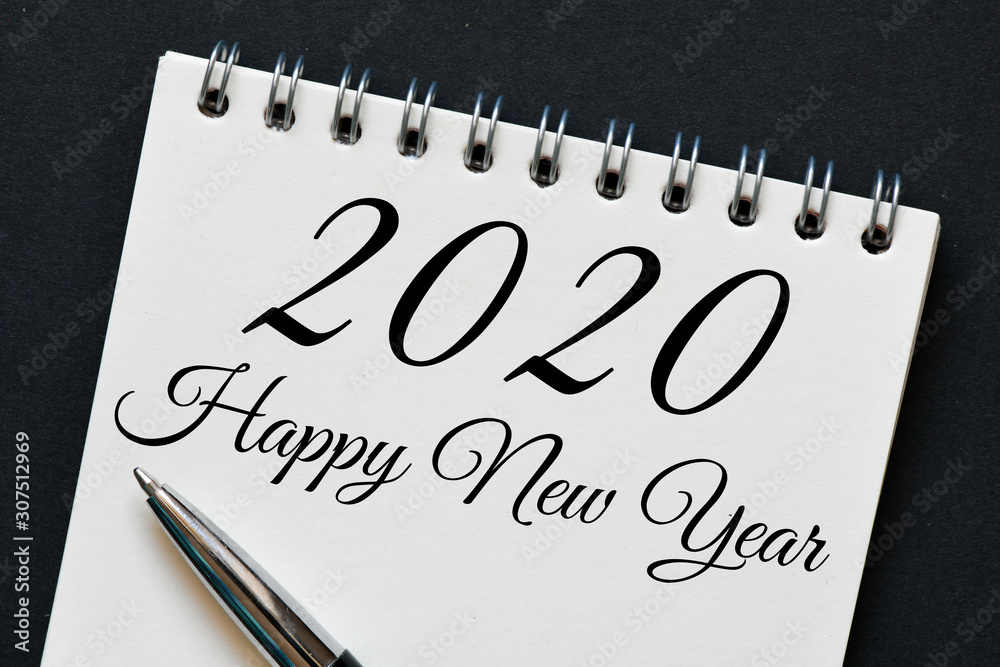 A close up of a Happy New Year 2020 message on a piece of paper with a pen. A close up of a Happy New Year 2020 message on a piece of paper with a pen.