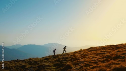 Aerial shot of a woman and a man running together in the hills