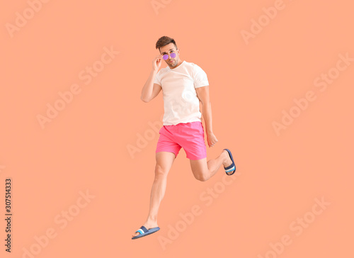 Jumping young man in beachw...