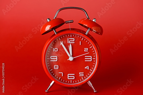 Red alarm clock on color background