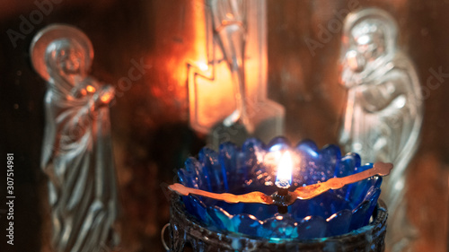 Orthodox Church Lamp with lit Candle and Blue Glass on the icon background.
