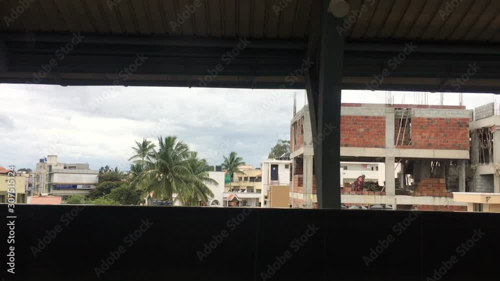 Side view out of train window while driving out of train station in India Side view out of train window while driving out of train station in India