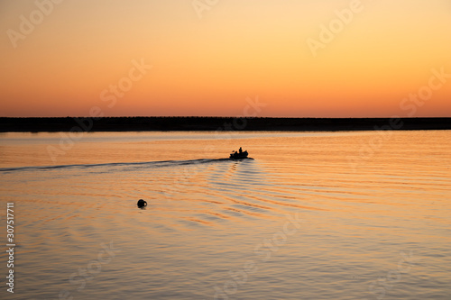 Fishermen in rowing boat at sunset in Douro River estuary, Porto, Portugal. Golden hour © Ana